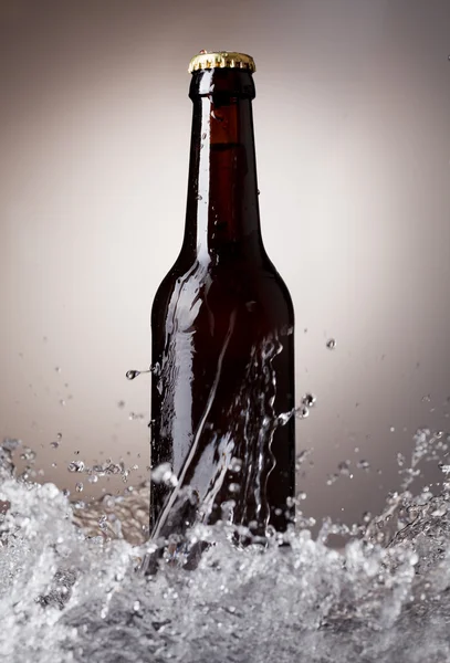 Пивна пляшка з бризками води — стокове фото