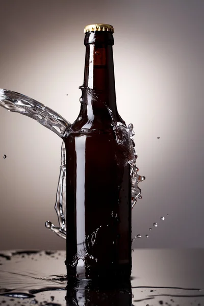 Пивна пляшка з бризками води — стокове фото