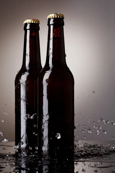 Botellas de cerveza con agua salpicada — Foto de Stock