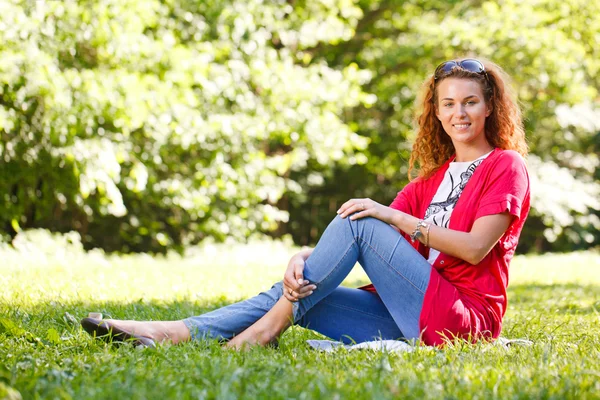 Frau sitzt auf Gras im Park — Stockfoto