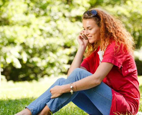 Woman talking over the phone in park — Stock Photo, Image