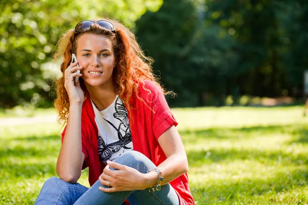 Женщина разговаривает по телефону в парке — стоковое фото