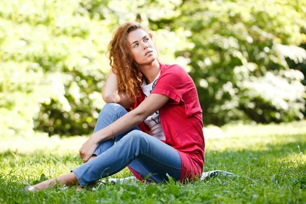 Vrouw zitten op gras in park — Stockfoto