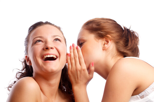 Young woman whispering something to her frind.