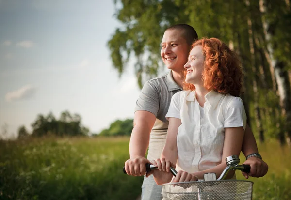 年轻夫妇坐在一辆自行车和看到的东西 — 图库照片