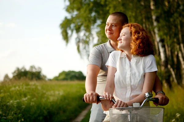Giovane coppia seduta una bicicletta e guardando qualcosa — Foto Stock