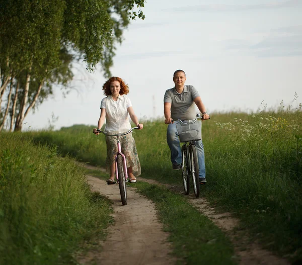Felice giovane coppia in sella a una bicicletta — Foto Stock