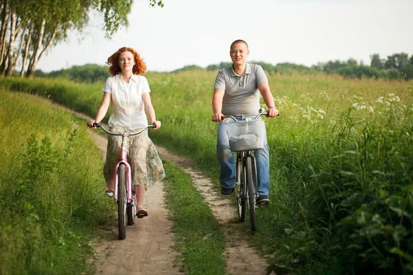 Feliz jovem casal montando em uma bicicleta — Fotografia de Stock