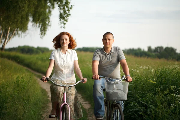 Feliz jovem casal montando em uma bicicleta — Fotografia de Stock