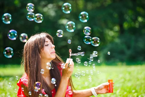 Mulher bonita soprando bolhas de sabão — Fotografia de Stock