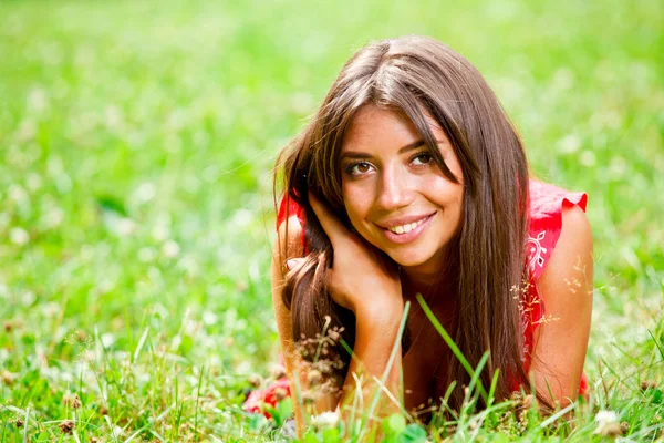 Hermosa mujer acostada en una hierba — Foto de Stock