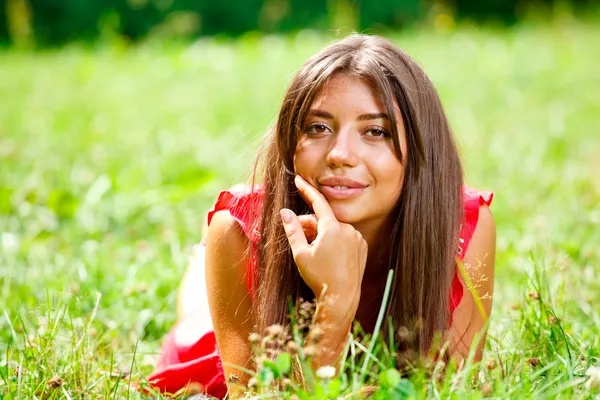 Hermosa mujer acostada en una hierba — Foto de Stock