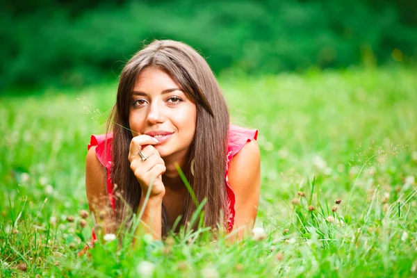Schöne Frau auf einem Gras liegend — Stockfoto