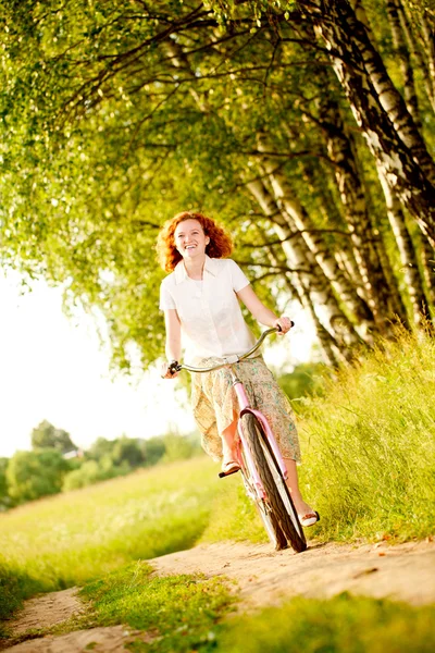 Mujer joven montando en bicicleta — Foto de Stock