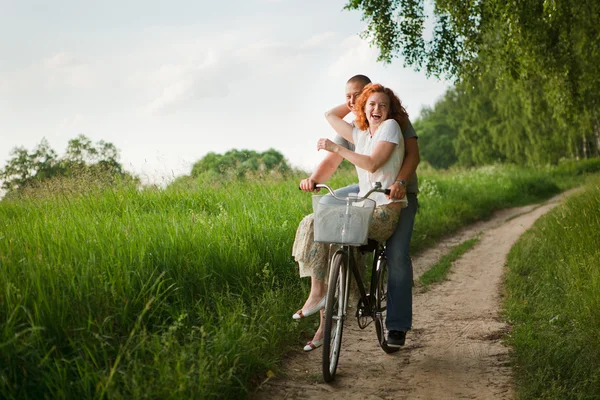 Mutlu genç bir çift bir bisiklet sürme — Stok fotoğraf