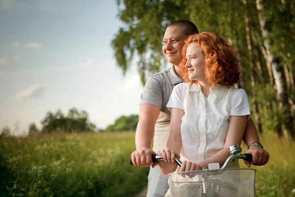 Giovane coppia seduta una bicicletta e guardando qualcosa — Foto Stock