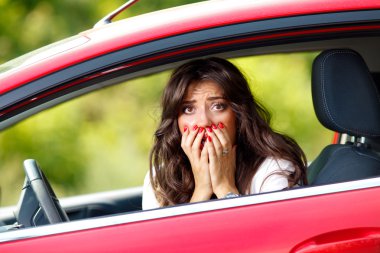Young pretty woman in the red car clipart