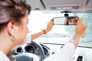 Young woman corrected rear view mirror clipart