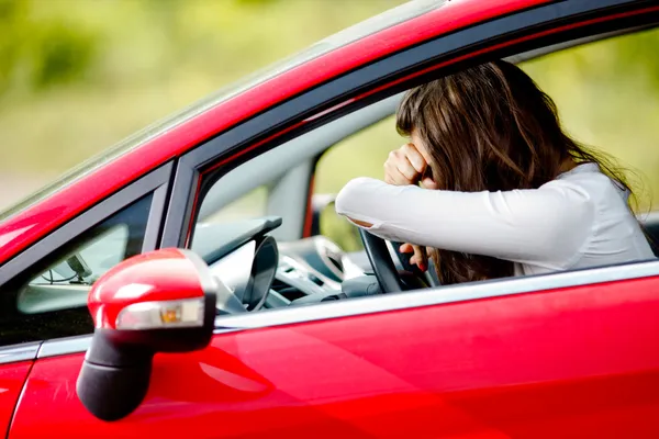 Mladá žena sedící depresi v autě — Stock fotografie