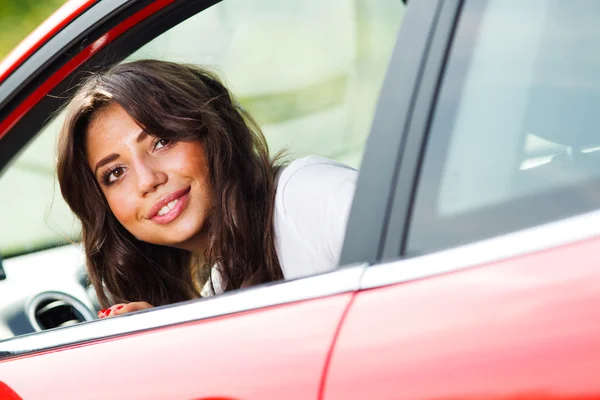 Молодая красивая женщина смотрит на заднюю часть автомобиля — стоковое фото
