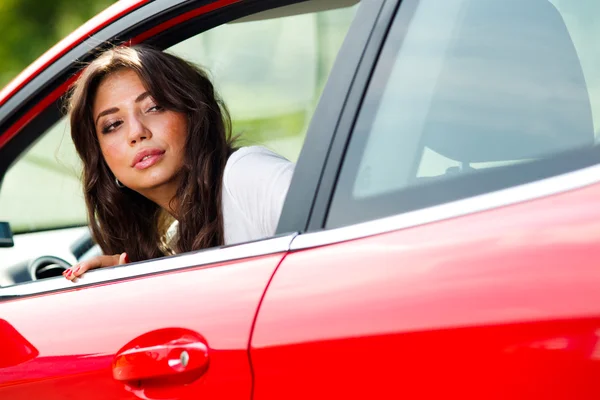 Молодая красивая женщина смотрит на заднюю часть автомобиля — стоковое фото