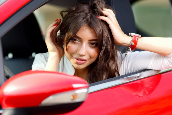 Jeune jolie femme dans la voiture rouge — Photo