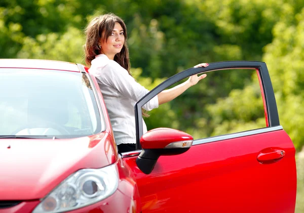 Junge hübsche Frau im roten Auto — Stockfoto