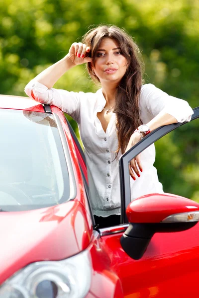 Giovane bella donna in macchina rossa — Foto Stock