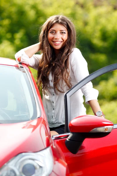 Kırmızı arabadaki genç güzel kadın — Stok fotoğraf