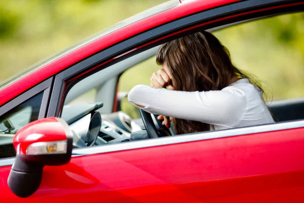 Mujer joven sentada deprimida en coche — Foto de Stock