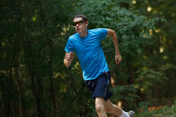 Junger Jogger läuft im Park herum — Stockfoto