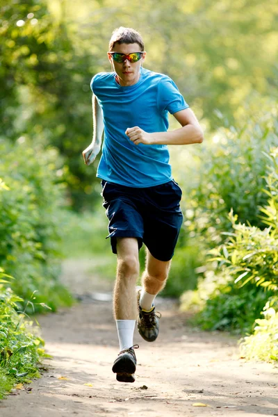 Ung joggare springande i parken — Stockfoto