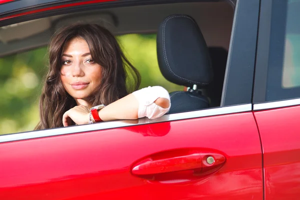 Jonge mooie vrouw in de rode auto — Stockfoto