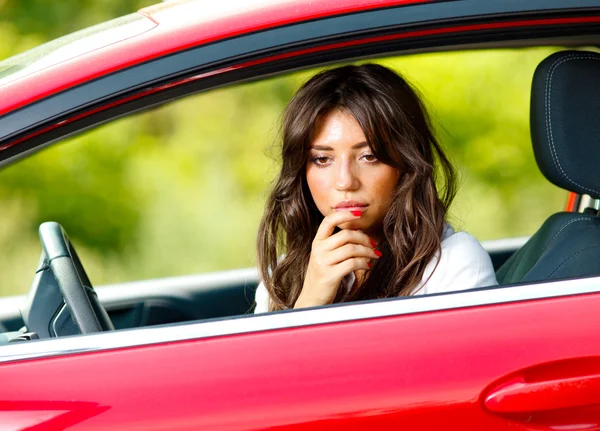 Joven mujer bonita en el coche rojo — Foto de Stock