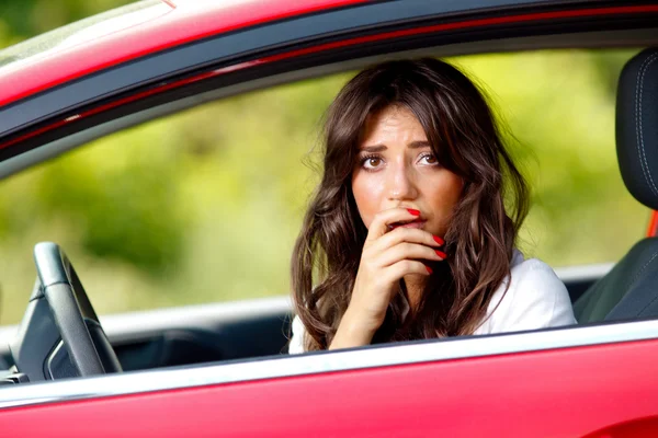 Młody bardzo przestraszona kobieta w samochodzie — Zdjęcie stockowe