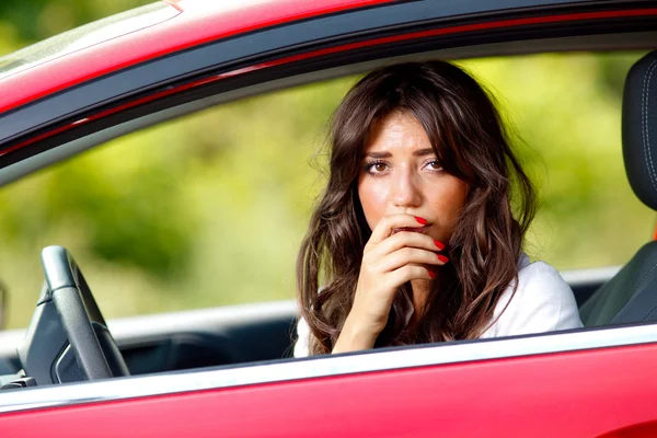 Mladá pěkně vyděšená žena v autě — Stock fotografie