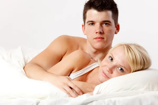 Liefdevolle aanhankelijk heteroseksueel paar op bed. — Stockfoto