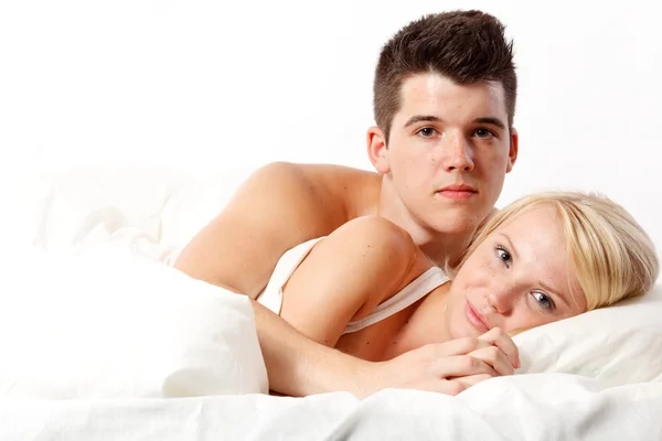 Liefdevolle aanhankelijk heteroseksueel paar op bed. — Stockfoto
