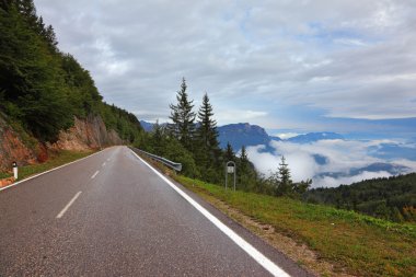 Wet road in the Swiss, low cumulus clouds clipart