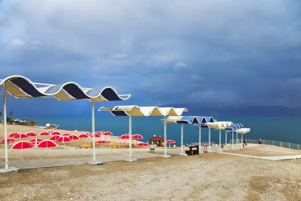 Красные пляжные зонтики на пустом месте в грозу — стоковое фото