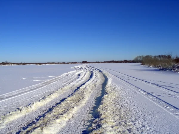 Зимняя дорога на ледяной реке — стоковое фото