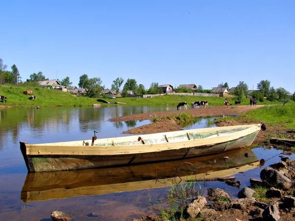Barco de madeira perto de aldeias — Fotografia de Stock