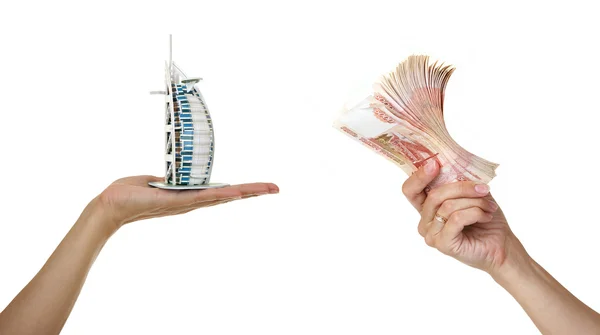 Model Burj Al Arab and a pack of five thousandth of notes in wom — Stock Photo, Image