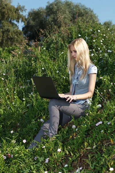 Bella ragazza che lavora con il computer portatile all'aperto . — Foto Stock