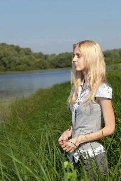 Langhaarige Blondine wartet am Ufer. — Stockfoto