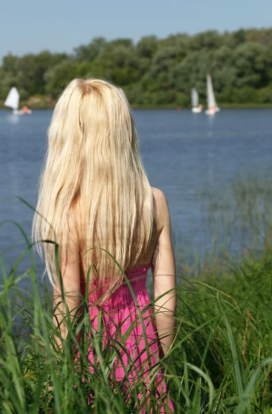 Loira de cabelos compridos está esperando na costa . — Fotografia de Stock