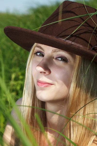 Mooi meisje in een hoed buitenshuis. — Stockfoto