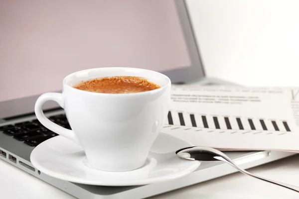 Filiżanka cappuccino z laptopem i gazetą — Zdjęcie stockowe