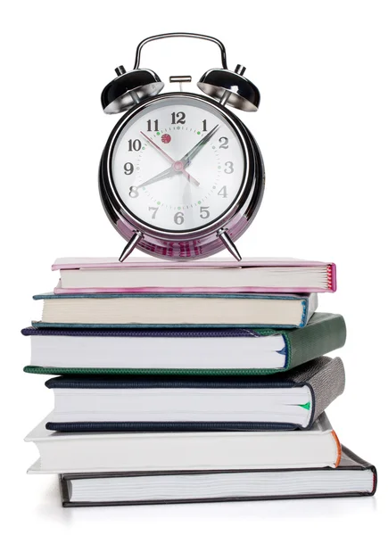 Reloj despertador en bloc de notas y libros — Foto de Stock