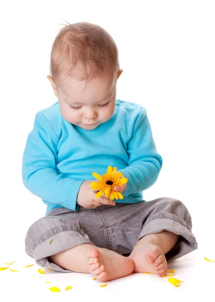 Kleine baby spelen met gele bloem — Stockfoto